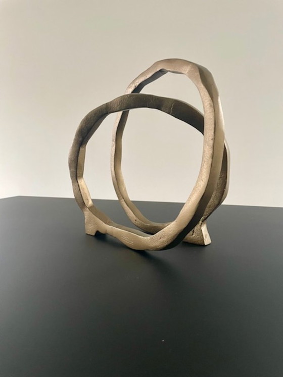 Image 1 of Escultura de diseño con forma de anillo abierto en oro mate.