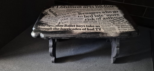 Decorative footstool with newspaper clippings
