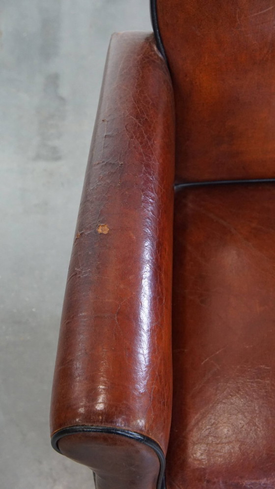 Image 1 of 2 x Vintage schapenleren eetkamerstoel met zwarte biezen op wieltjes