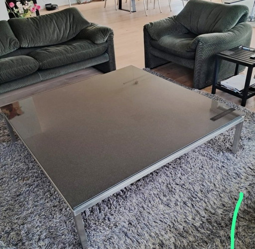 Table basse design avec plateau en granit noir et structure en acier inoxydable brossé