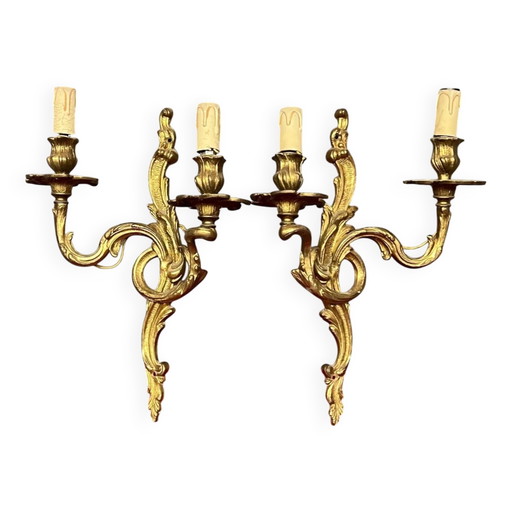 Een paar vergulde, massief bronzen wandlampen in rococostijl.
