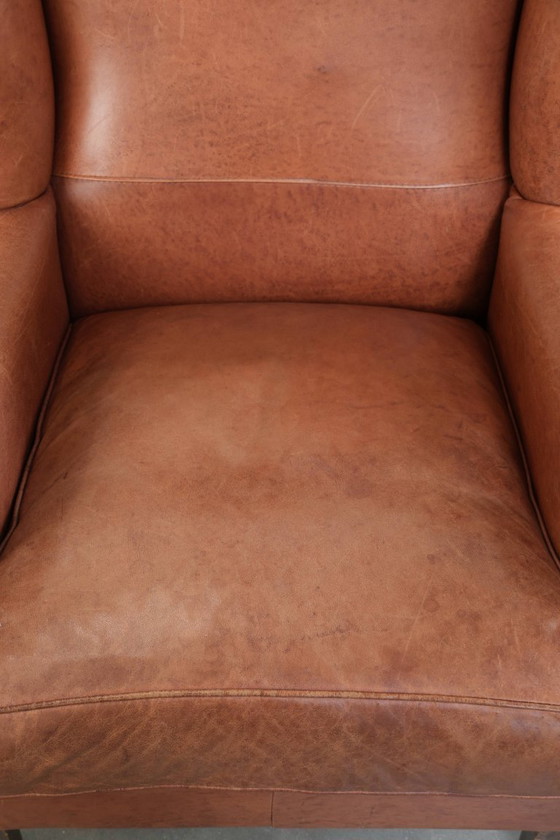 Image 1 of Poltrona a orecchioni color cognac chiaro, rivestita in pelle bovina, dal caratteristico look inglese.