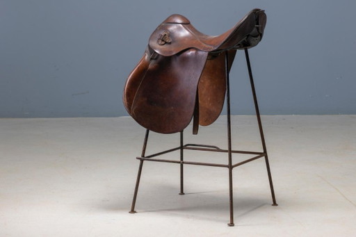 Coppia di sgabelli da bar stile sella, in pelle vintage e struttura in metallo, fine XX secolo.
