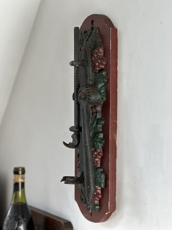Image 1 of Ouvre-bouteille mural ancien en fonte à motif de raisin – style auberge (vers 1900)