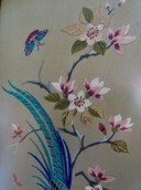 Tapisserie murale vintage brodée à la main, sous verre, avec une grue, des papillons et des fleurs.