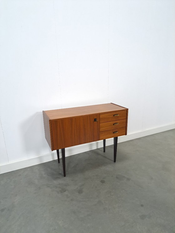 Image 1 of Mid-Century teak kastje op hoge zwarte poten met lades