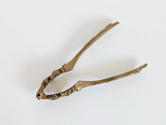 Image 1 of Vintage messing notenkraker met fleur-de-lys, sierlijke bloemenversiering voor een Hollywood Regency keuken.