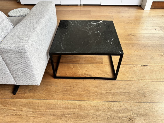 Image 1 of Elegante mesa de centro negra: tablero con efecto mármol y estructura de metal.
