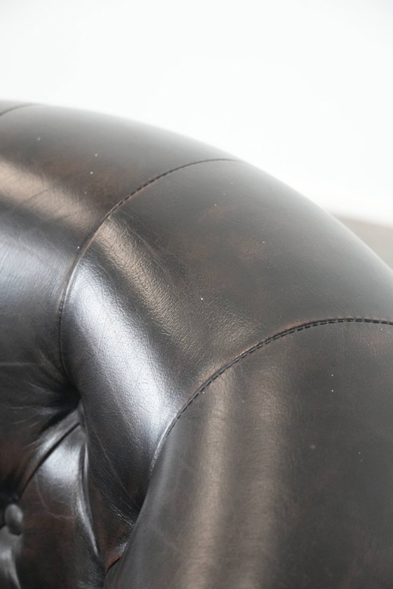 Image 1 of Donkere luxe rundleren Chesterfield clubfauteuil in Engelse stijl, afgewerkt met siernagels