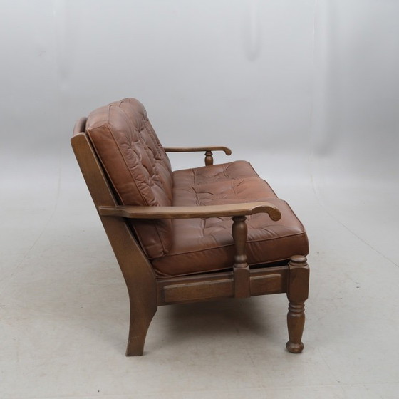 Image 1 of A vintage brown three-piece sofa set in leather with wooden armrests and turned legs, comprising a 1-seater, 2-seater and 3-seat