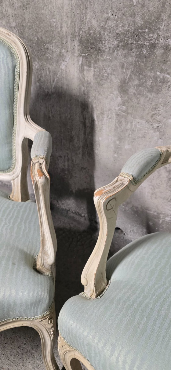 Image 1 of Coppia di poltrone in stile Luigi XV in legno patinato, con rivestimento in tessuto azzurro chiaro.