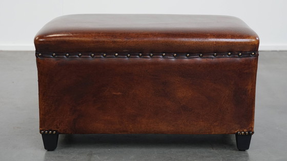 Image 1 of Cognac-kleurige schapenleren hocker met siernagels