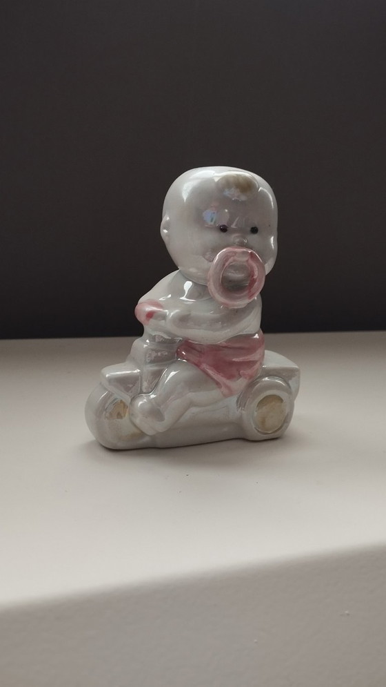 Image 1 of Lüsterware-Figur aus der Mitte des 20. Jahrhunderts – Baby auf Dreirad – Davis & Freeman (Japan/USA)