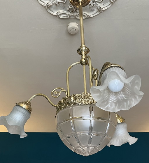 Lampadario Art Nouveau a quattro bracci in ottone e bronzo con globi in vetro satinato.