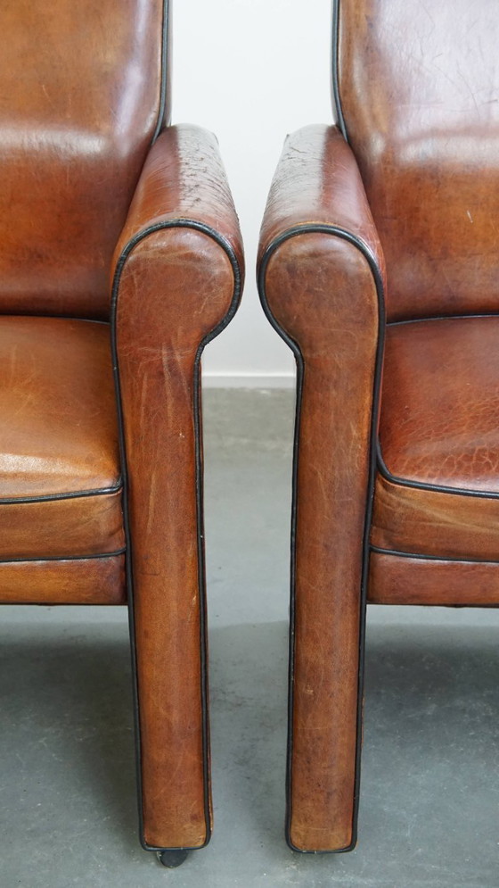 Image 1 of 4 x Vintage schapenleren eetkamerstoel met zwarte biezen op wieltjes