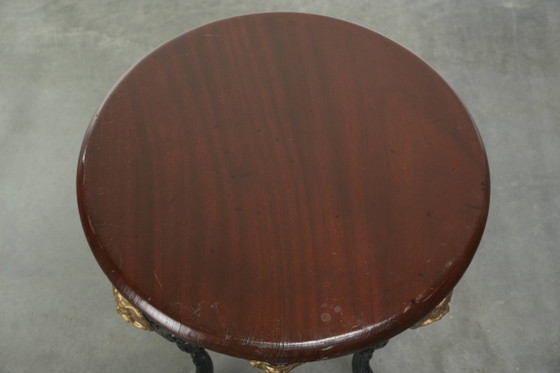 Image 1 of Antieke Engelse bistro/ bijzettafel met een gietijzeren onderstel uit begin 20e eeuw en een massief houten tafelblad