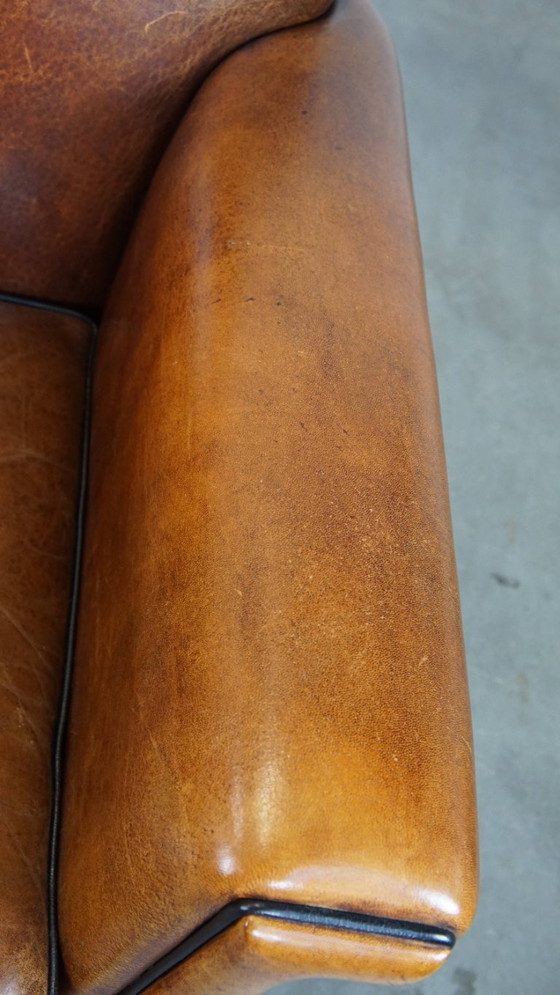 Image 1 of Sillón de diseño Art Déco en buen estado, con un acabado elegante y ribetes negros.
