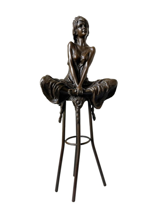 Statue en bronze d'une dame sur un tabouret de bar