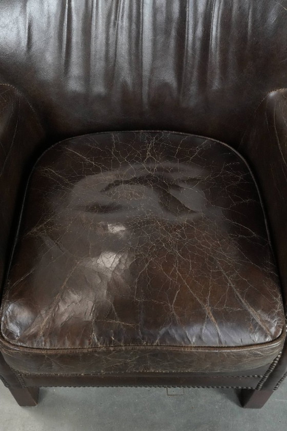 Image 1 of Subtiele donkerbruine fauteuil gemaakt van rundleer met een omkeerbaar Kelim zitkussen