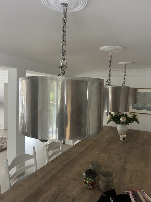 Lampada a sospensione con paralume cilindrico color argento e catena dimmerabile.