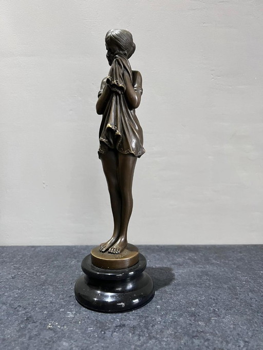 Scultura in bronzo di una donna in piedi su base di marmo