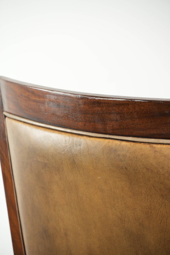 Image 1 of Cómodo sillón de diseño Art Déco en color coñac, fabricado en piel de oveja combinada con madera y con respaldo alto.