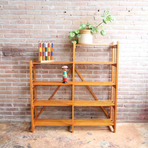 Estantería vintage con puertas de listones abiertos, ideal para juguetes y libros.