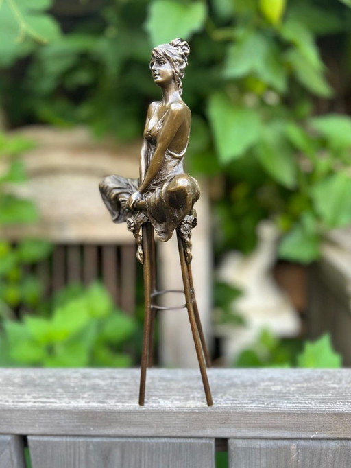 Bronzeskulptur einer sitzenden Dame auf einem Hocker