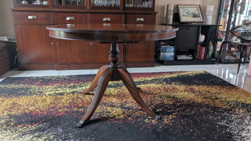 Extendable round mahogany dining table in Regency/English style