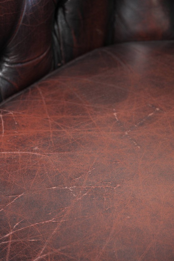 Image 1 of Canapé Chesterfield 2 places en cuir de vachette anglais ancien rouge/marron, au style magnifique et au charme intemporel.