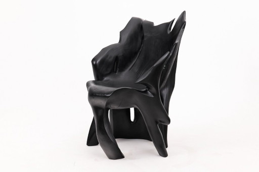 Fauteuil sculptural en bois noir carbonisé aux formes organiques par Logniture