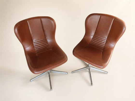 Image 1 of Een paar draaibare fauteuils uit de jaren 60/70 in bruin kunstleer en verchroomd metaal, vintage stoelen in de stijl van het mid