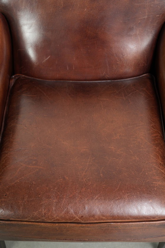 Image 1 of Bellissima poltrona in pelle di pecora in buone condizioni, con un bel colore intenso e una seduta confortevole.