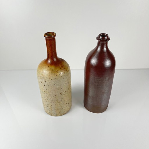 Duo of speckled stoneware and burgundy bottles