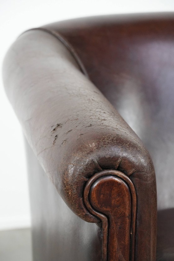 Image 1 of Sillón club marrón oscuro de piel de oveja con ribete fotocromático.