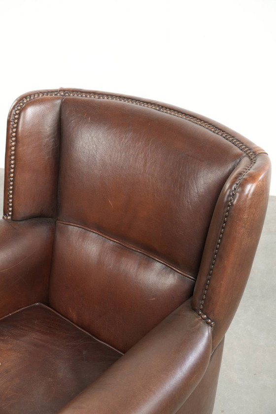 Wunderschöner, dezenter Ohrensessel aus Schaffell in einem tiefen Cognac-Ton mit bequemer Sitzfläche (photo 12 of 12)