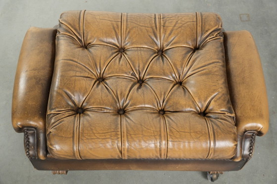 Image 1 of Exclusivo y elegante puf inglés Chesterfield de piel de vacuno con ruedas y acabado con clavos decorativos.