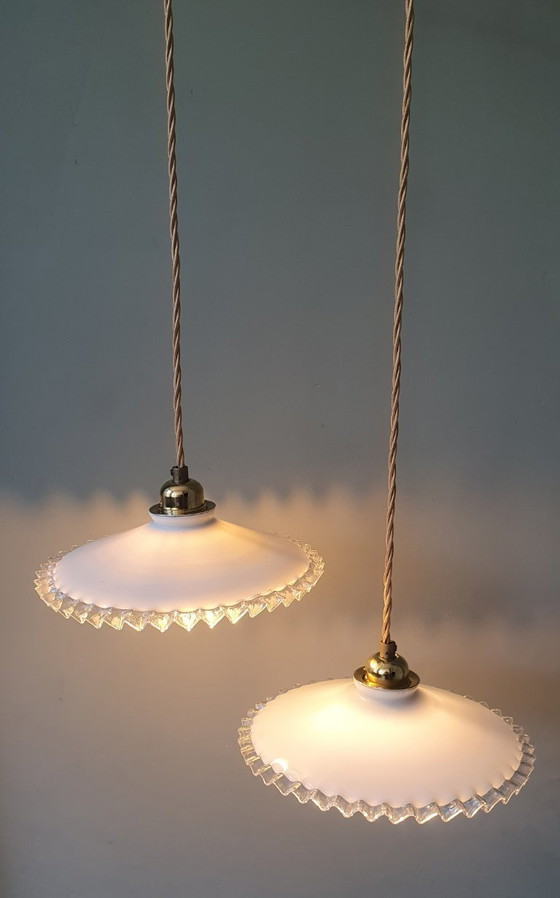 Image 1 of 2 vintage hanglampen van wit opaline glas met een transparante sierrand.