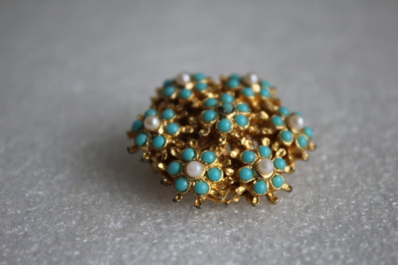 Image 1 of Ronde vintage broche, goudkleurig metaal met kleine groene en witte parels.