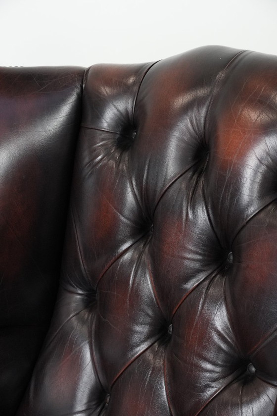 Image 1 of Poltrona Chesterfield con braccioli in pelle bovina marrone, in classico stile inglese.