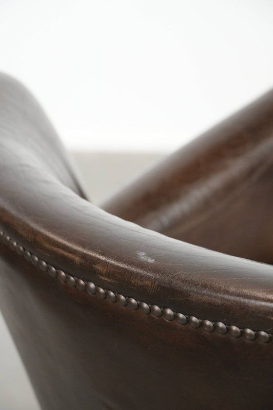 Image 1 of Subtiele donkerbruine fauteuil gemaakt van rundleer met een omkeerbaar Kelim zitkussen