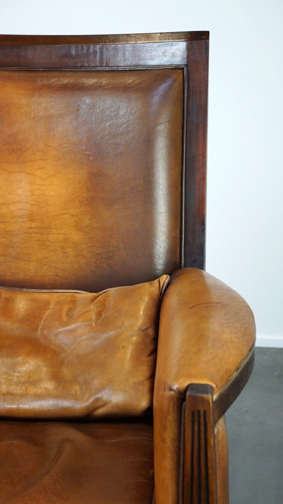 Image 1 of Schapenleren Art Deco design fauteuil met een hoge rugleuning en afwerking met hout