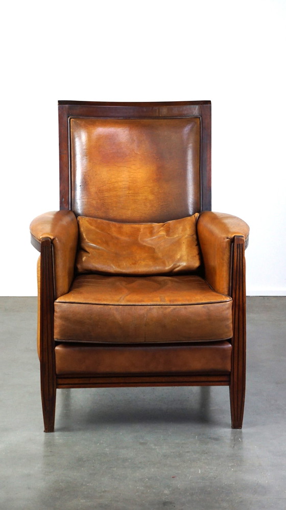 Image 1 of Schapenleren Art Deco design fauteuil met een hoge rugleuning en afwerking met hout