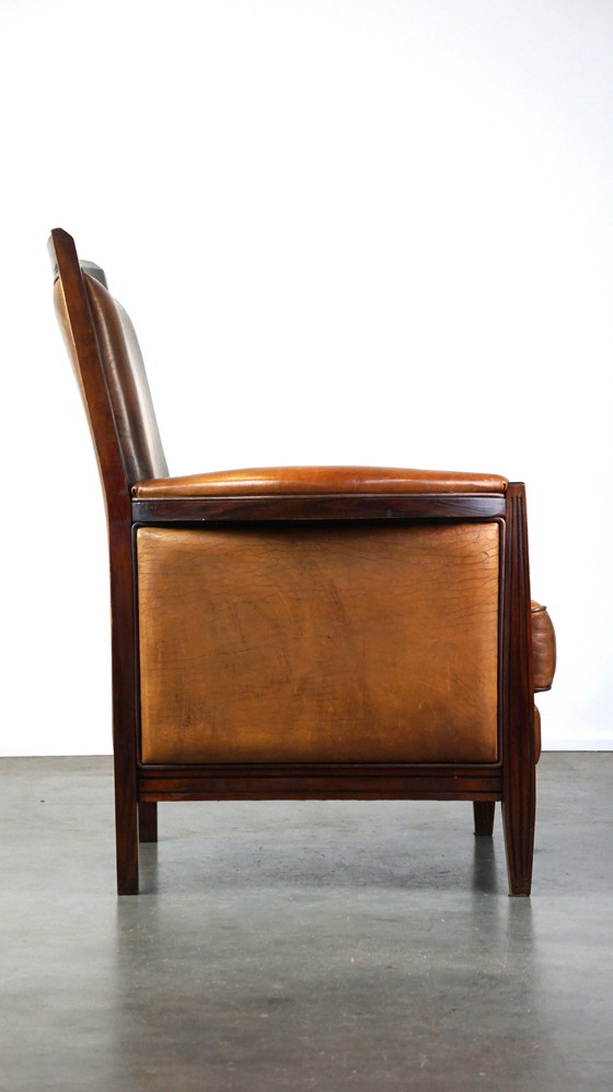 Image 1 of Schapenleren Art Deco design fauteuil met een hoge rugleuning en afwerking met hout