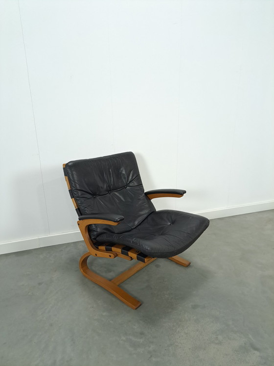 Image 1 of Zwart leren fauteuil met armleuningen en houten onderstel