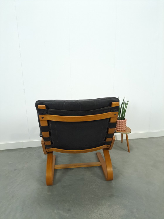 Image 1 of Zwart leren fauteuil met armleuningen en houten onderstel