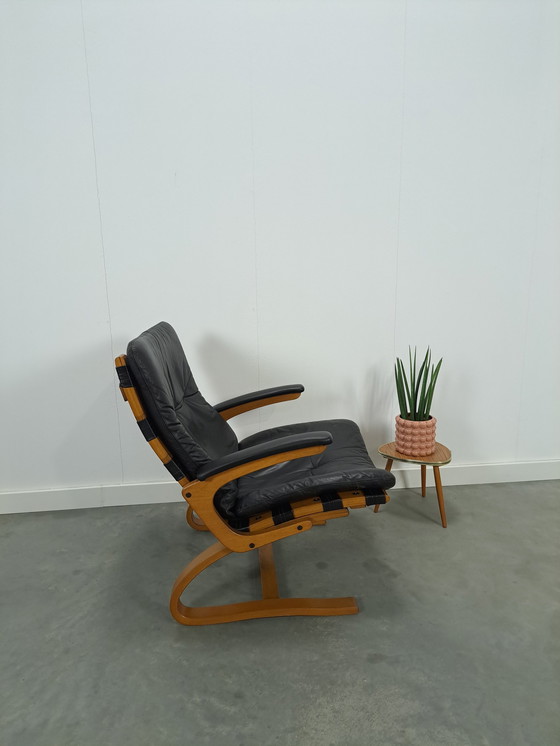 Image 1 of Zwart leren fauteuil met armleuningen en houten onderstel