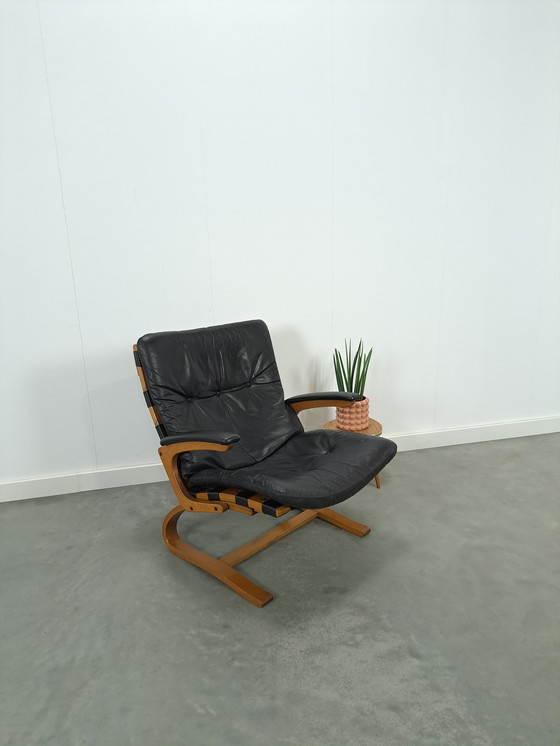 Image 1 of Zwart leren fauteuil met armleuningen en houten onderstel