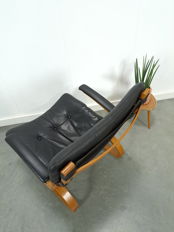 Image 1 of Zwart leren fauteuil met armleuningen en houten onderstel