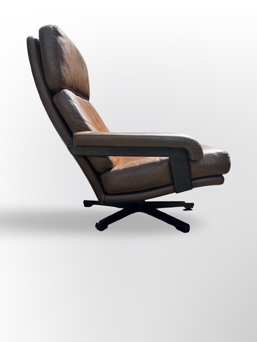 Prachtige vintage design Leolux draaifauteuil, uitgevoerd in bruin leer en houten frame. 